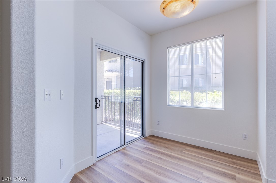 9050 West Warm Springs Road, Unit 1011 Las Vegas, NV 89148 - Photo 5 of 32 Sun-filled room boasts resilient hardwood flooring and direct access to an intimate patio area.