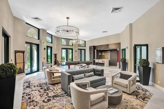 a living room with furniture chandelier and a rug