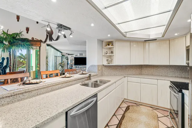a kitchen with sink refrigerator and cabinets