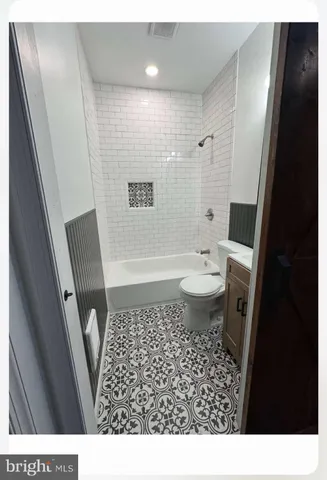 a bathroom with a sink a toilet a shower and a mirror
