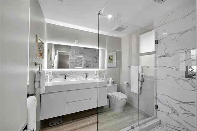 a bathroom with a double vanity sink toilet mirror and shower