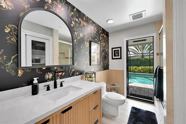 a bathroom with a granite countertop sink mirror vanity and toilet