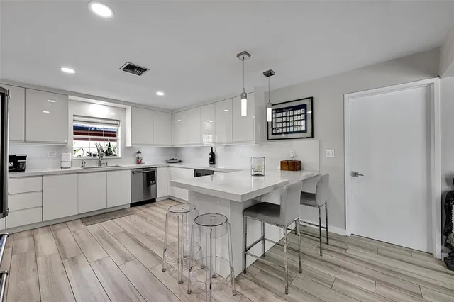 a kitchen with a sink cabinets and wooden floor