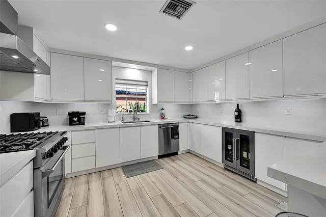 a kitchen that has a lot of cabinets a sink and appliances in it
