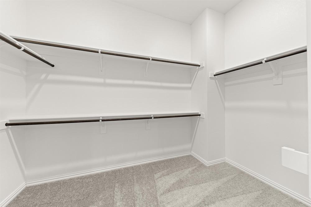 1237 Doris May Drive Allen, TX 75013 - Photo 13 of 19 Walk-in closet featuring light gray carpeting, white baseboards, and white shelving with dark-finish hanging rods