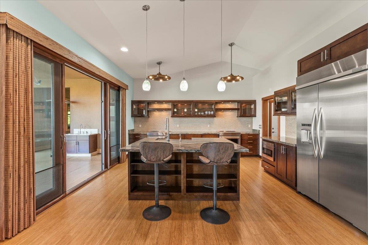 10 Leleaka Place Haiku, HI 96708 - Photo 22 of 49 a kitchen with stainless steel appliances granite countertop a stove top oven a dining table and chairs with wooden floor