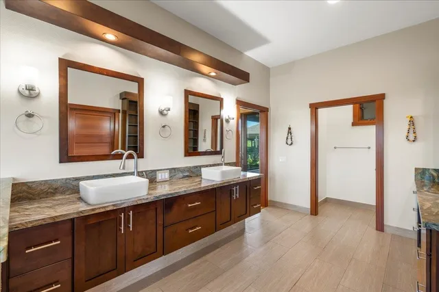 a spacious bathroom with a sink double vanity granite and a large mirror