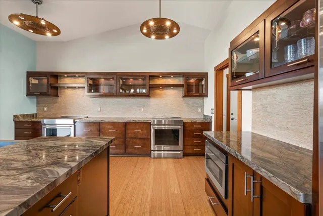 a kitchen with stainless steel appliances granite countertop a stove and cabinets