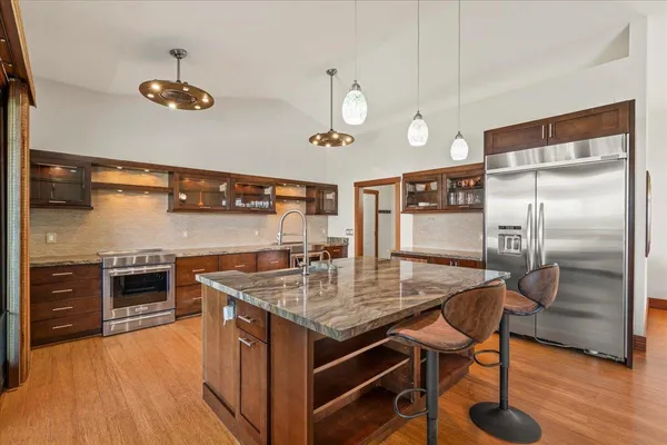 a kitchen with stainless steel appliances granite countertop a sink a stove and a refrigerator