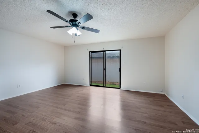 a view of an empty room with wooden floor