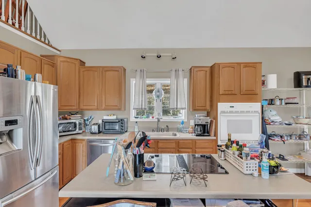 a kitchen with stainless steel appliances a sink a refrigerator a counter and cabinets