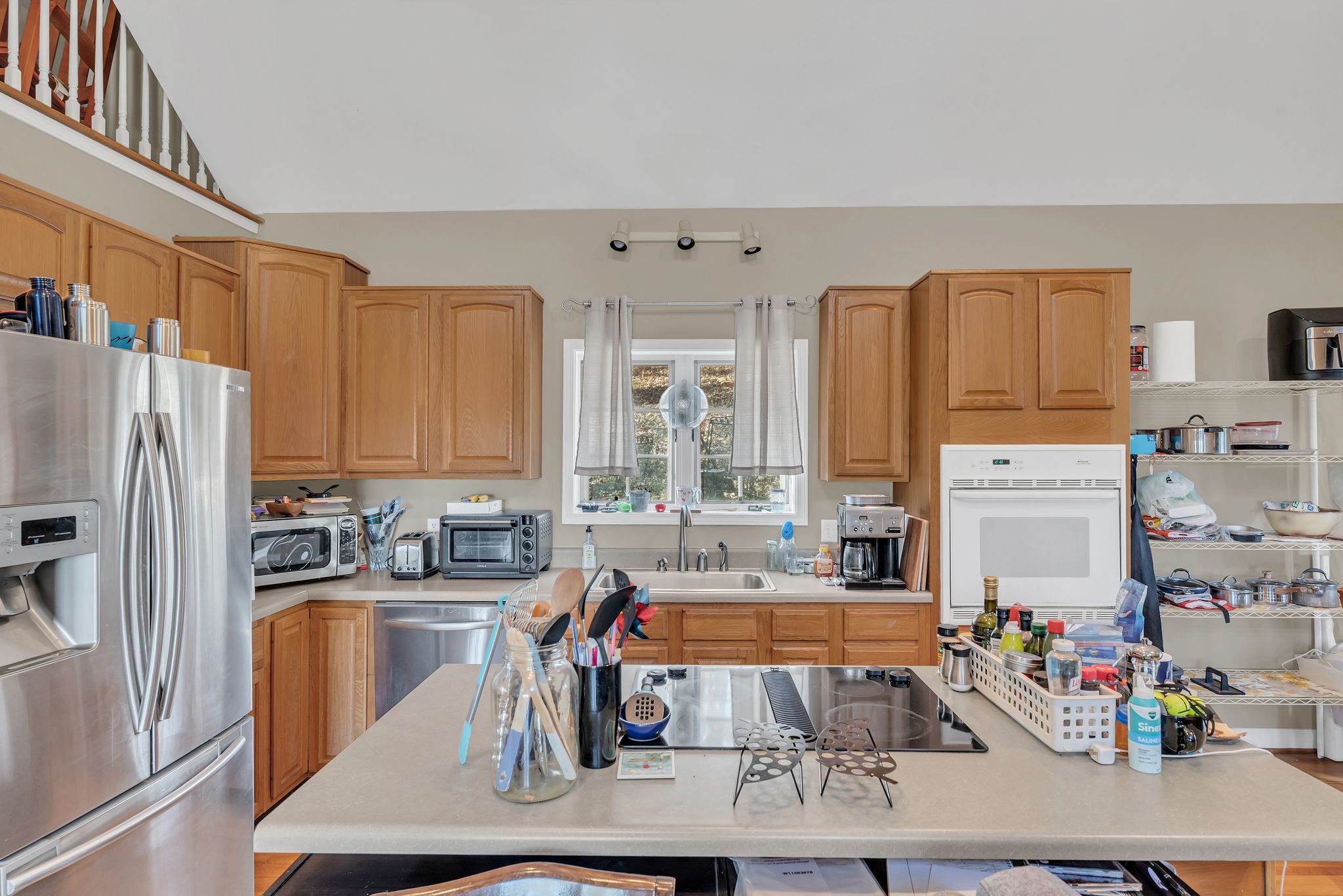8242 River Rd Pike Nashville, TN 37209 - Photo 16 of 35 a kitchen with stainless steel appliances a sink a refrigerator a counter and cabinets