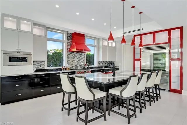 a kitchen with stainless steel appliances granite countertop a stove a sink dishwasher a dining table and chairs with wooden floor