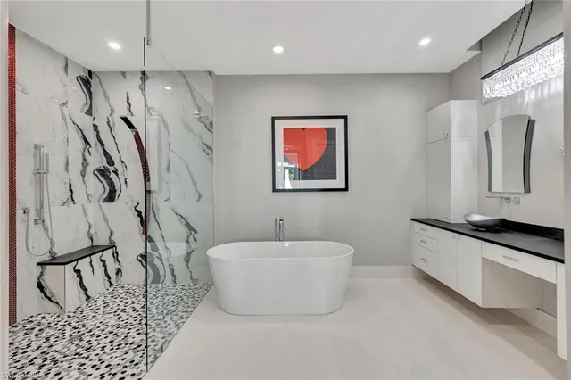 a bathroom with a large tub sink vanity and mirror
