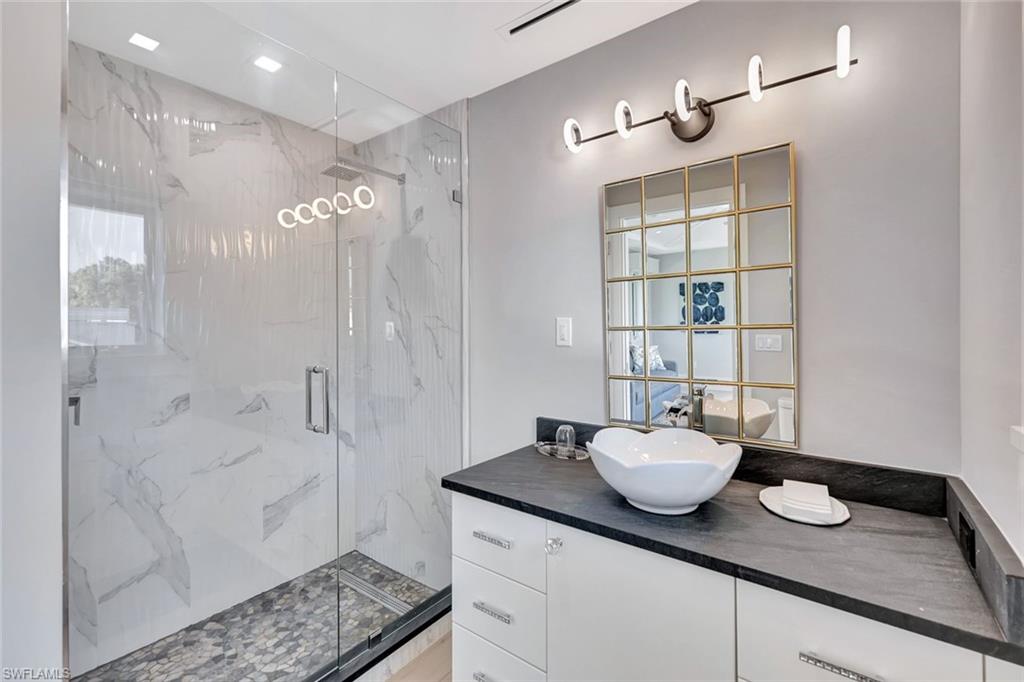 739 5th Avenue North Naples, FL 34102 - Photo 35 of 35 a bathroom with a granite countertop sink a mirror and shower