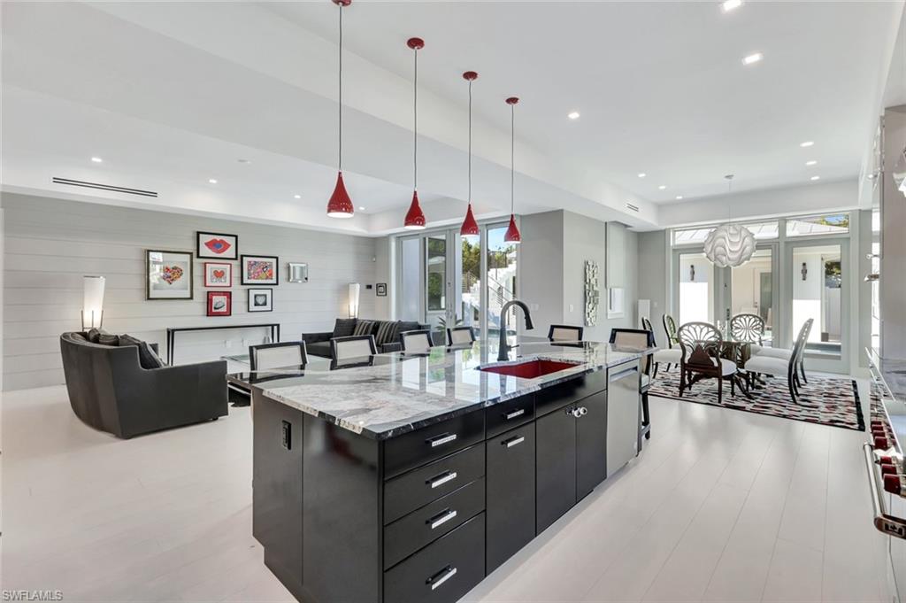 739 5th Avenue North Naples, FL 34102 - Photo 9 of 35 a kitchen island with granite countertop a sink a counter top space and living room view
