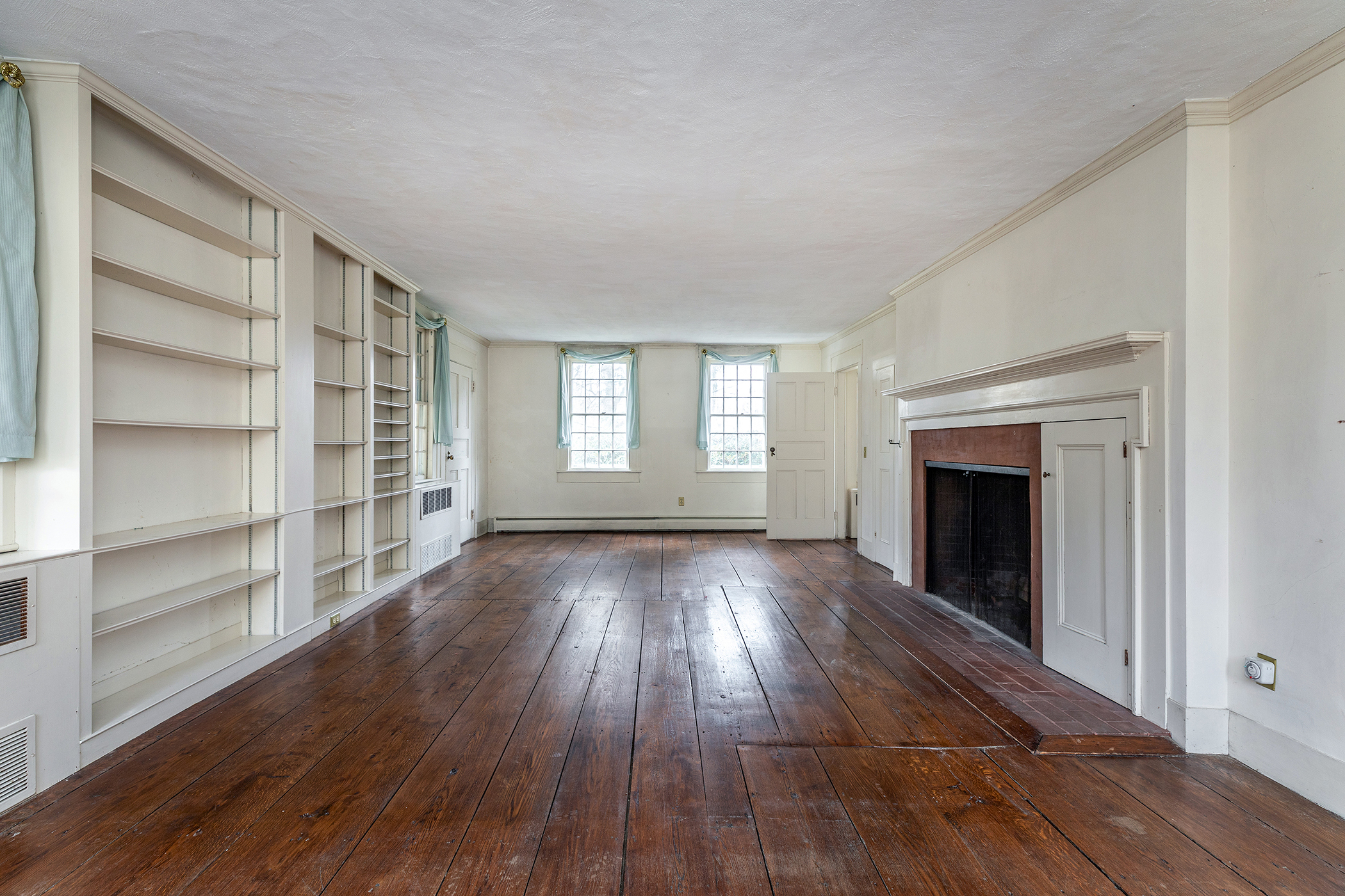 28 Sunny Ridge Road Washington, CT 06793 - Photo 12 of 35 a view of an empty room with a fireplace and a window