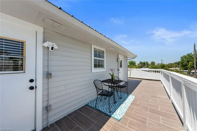 a view of a balcony with wooden chairs and city view