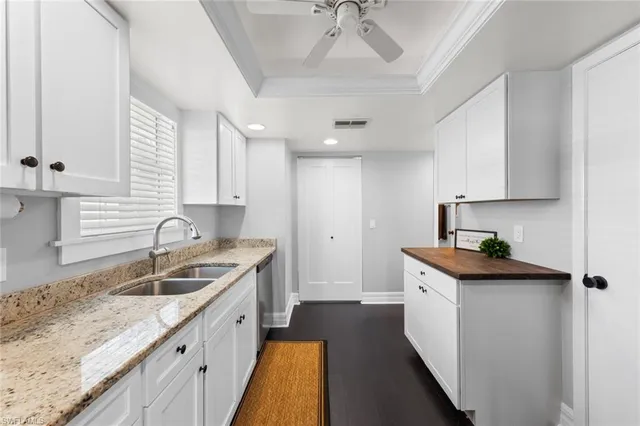 a kitchen with granite countertop a sink stove and cabinets
