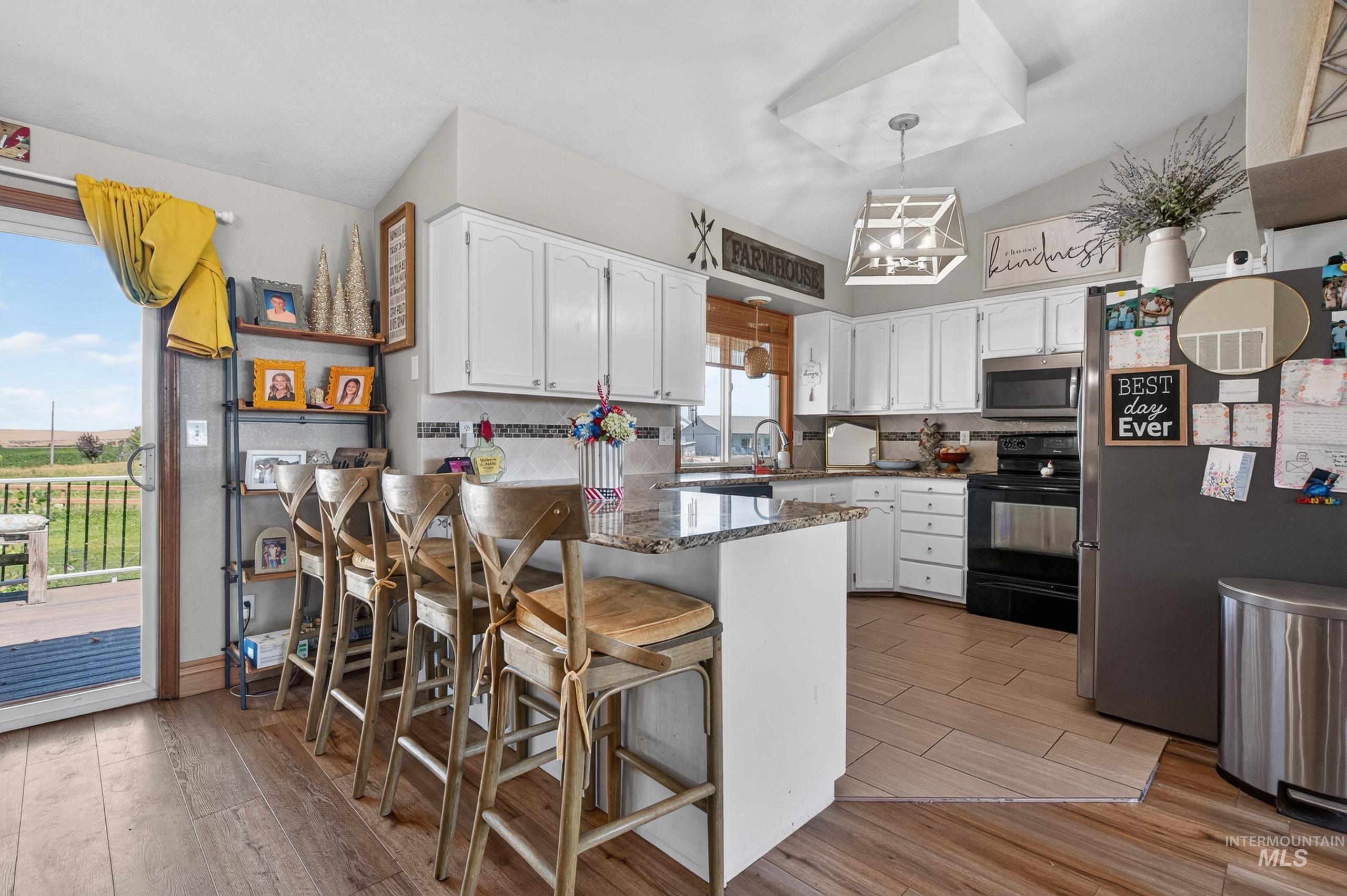 9696 Gloria Road Middleton, ID 83644 - Photo 12 of 50 Kitchen featuring white cabinetry, granite countertops, and a tiled backsplash