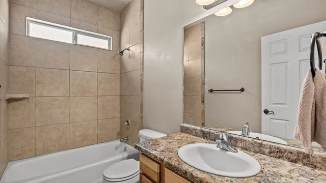 a bathroom with a granite countertop sink toilet and shower