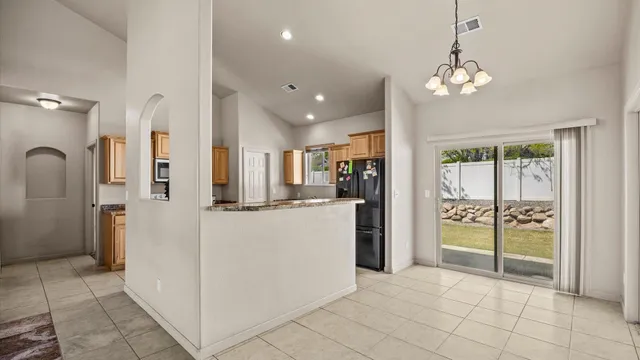 a view of a kitchen with refrigerator and natural light