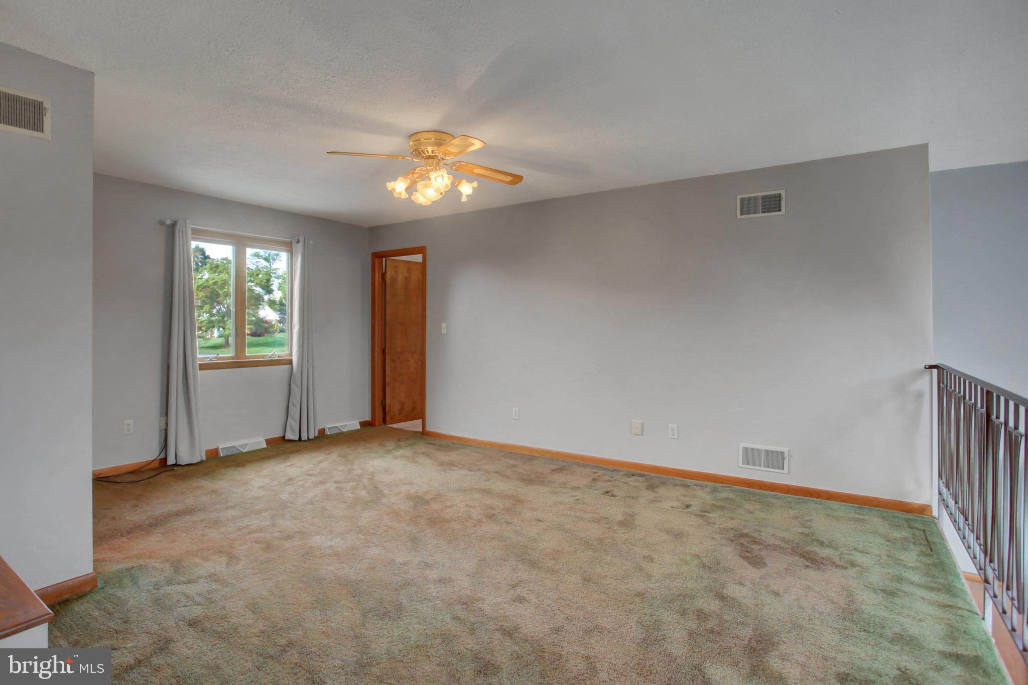 10050 McCreary Road Shippensburg, PA 17257 - Photo 37 of 64 an empty room with windows and chandelier fan