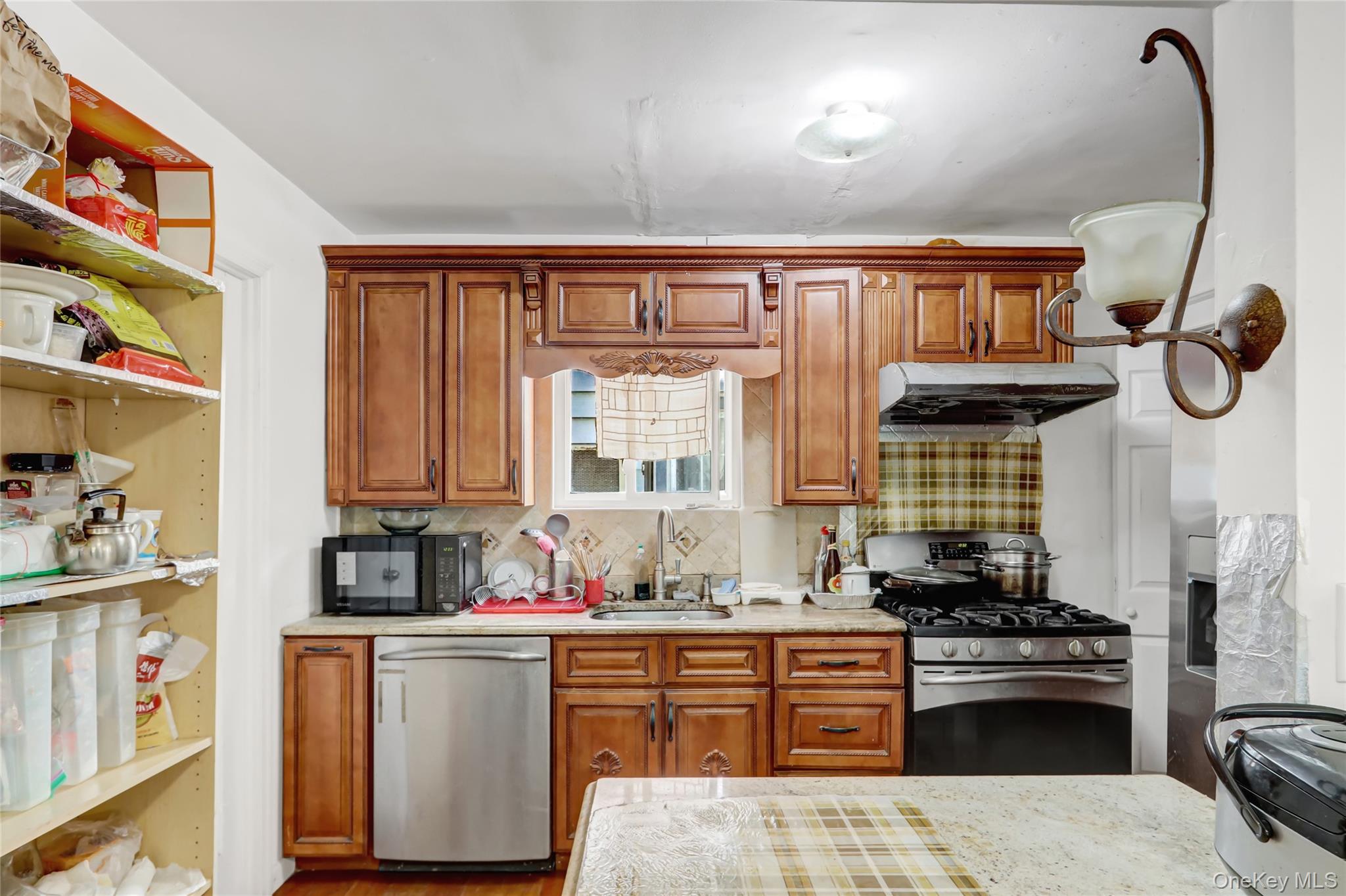 6 Walnut Place Great Neck, NY 11021 - Photo 8 of 19 a kitchen with stainless steel appliances granite countertop a stove a sink and a refrigerator