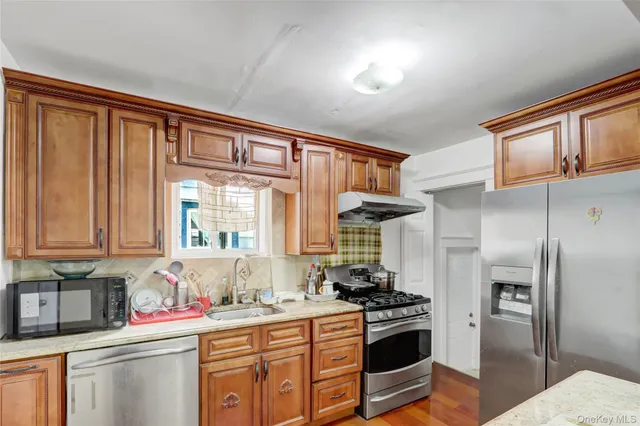 a kitchen with stainless steel appliances granite countertop a refrigerator sink and stove