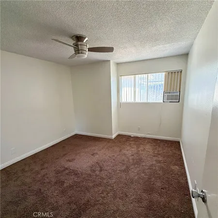 en empty room with windows and chandelier fan