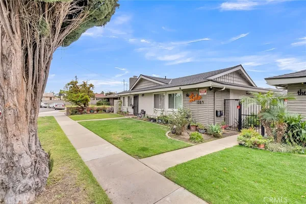 a front view of a house with a yard and potted plants