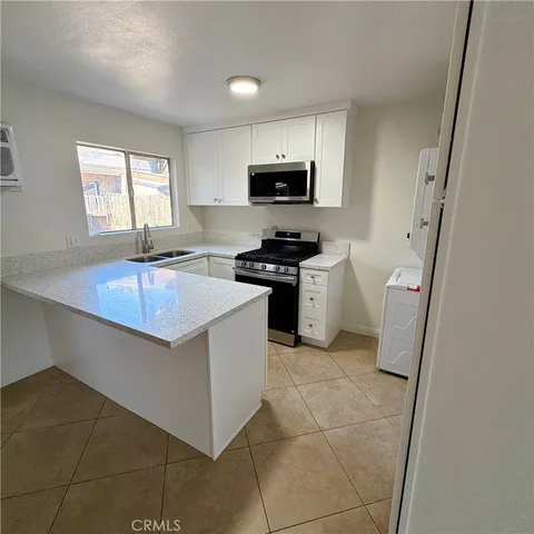 a kitchen with stainless steel appliances a stove a sink a microwave and a refrigerator