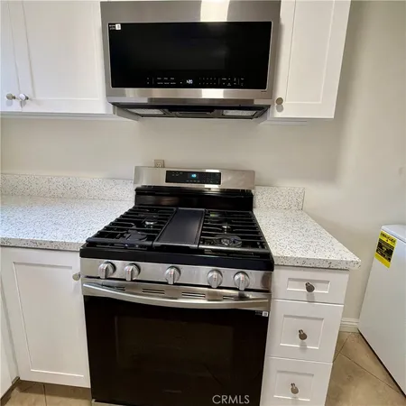 a stove top oven sitting inside of a kitchen
