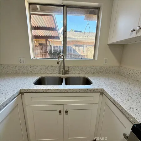 a view of kitchen sink a window cabinets and stainless steel appliances
