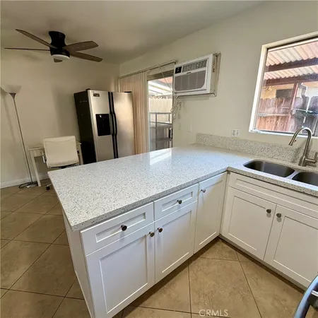 a kitchen with stainless steel appliances white cabinets and window