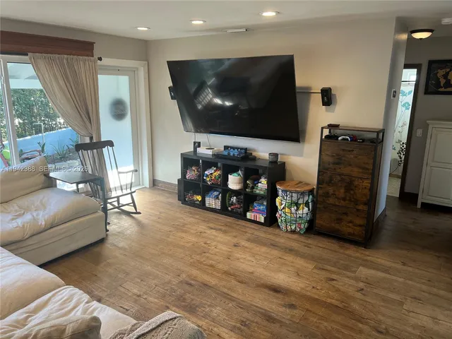 a kitchen with a refrigerator and a view of living room