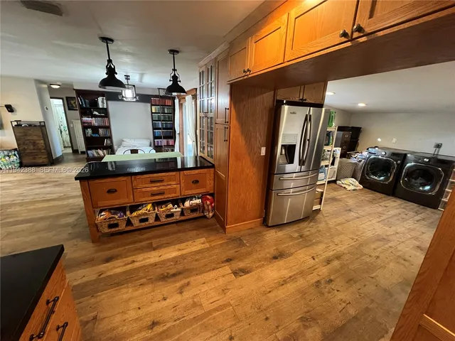 a kitchen with stainless steel appliances granite countertop a refrigerator and a sink