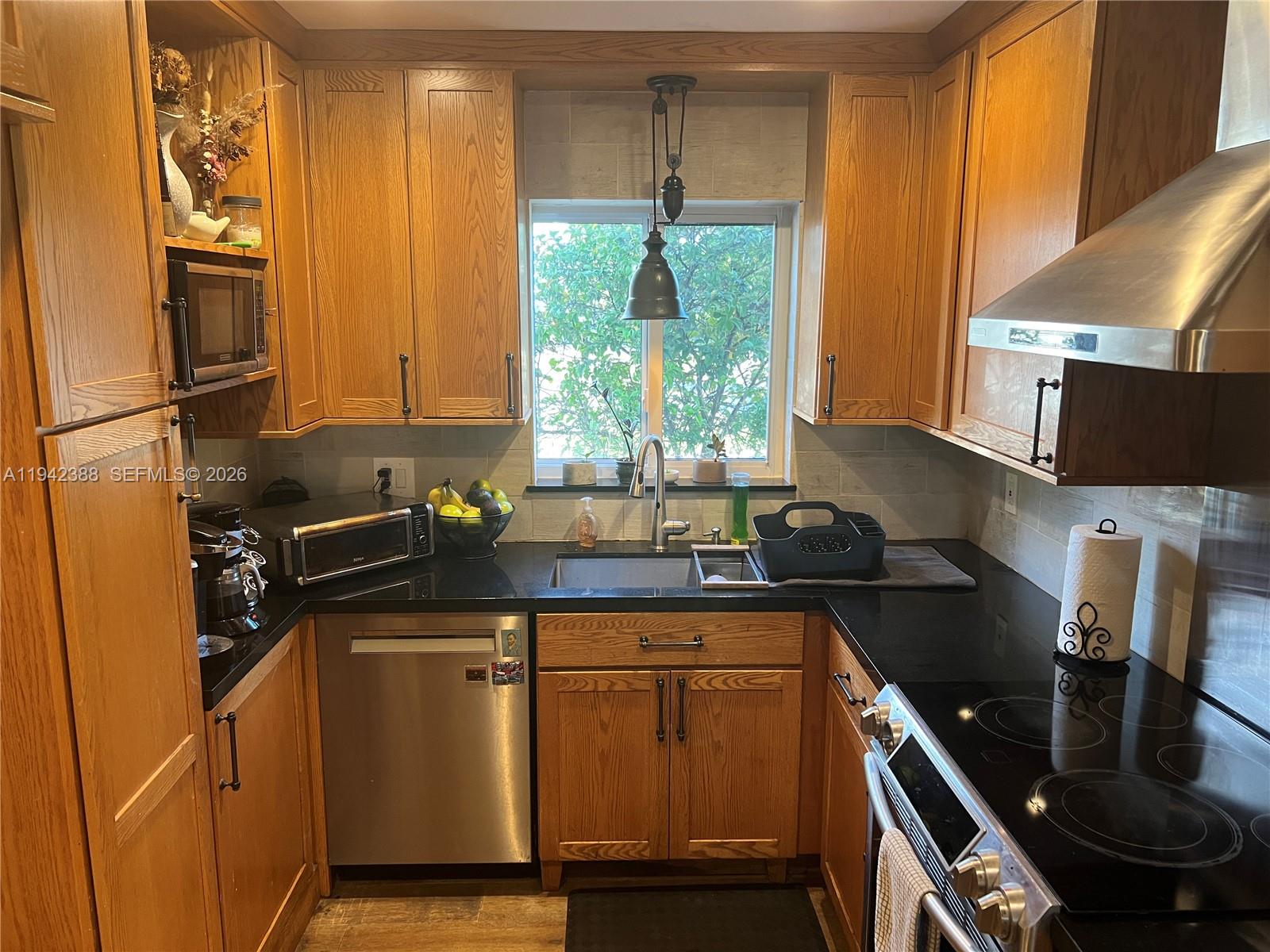8801 Southwest 42nd Street Miami, FL 33165 - Photo 40 of 75 a kitchen with stainless steel appliances granite countertop a sink stove and refrigerator