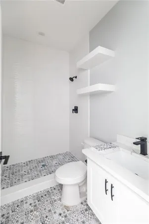 a bathroom with a sink a toilet and a shower