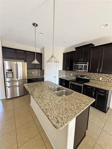 a kitchen with stainless steel appliances kitchen island granite countertop a sink counter space cabinets and appliances
