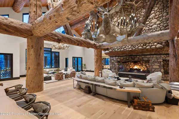 a living room with furniture a chandelier and a fireplace