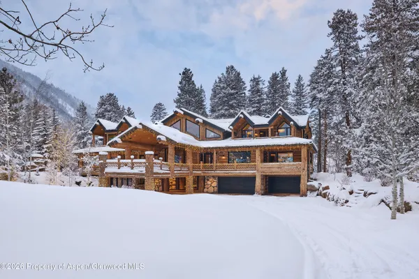 a front view of a house with a yard covered with snow in front of house