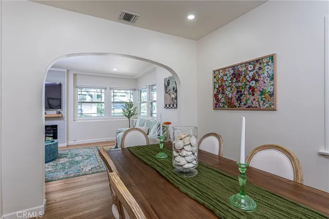 a view of a dining room with furniture a rug and wooden floor