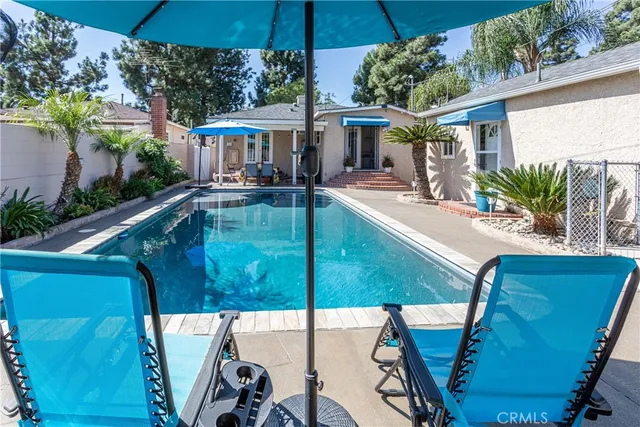 a view of a patio with table and chairs under an umbrella