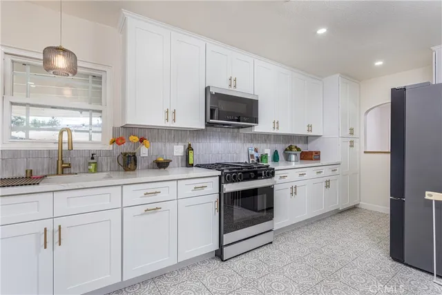 a kitchen with stainless steel appliances granite countertop a refrigerator and a stove top oven