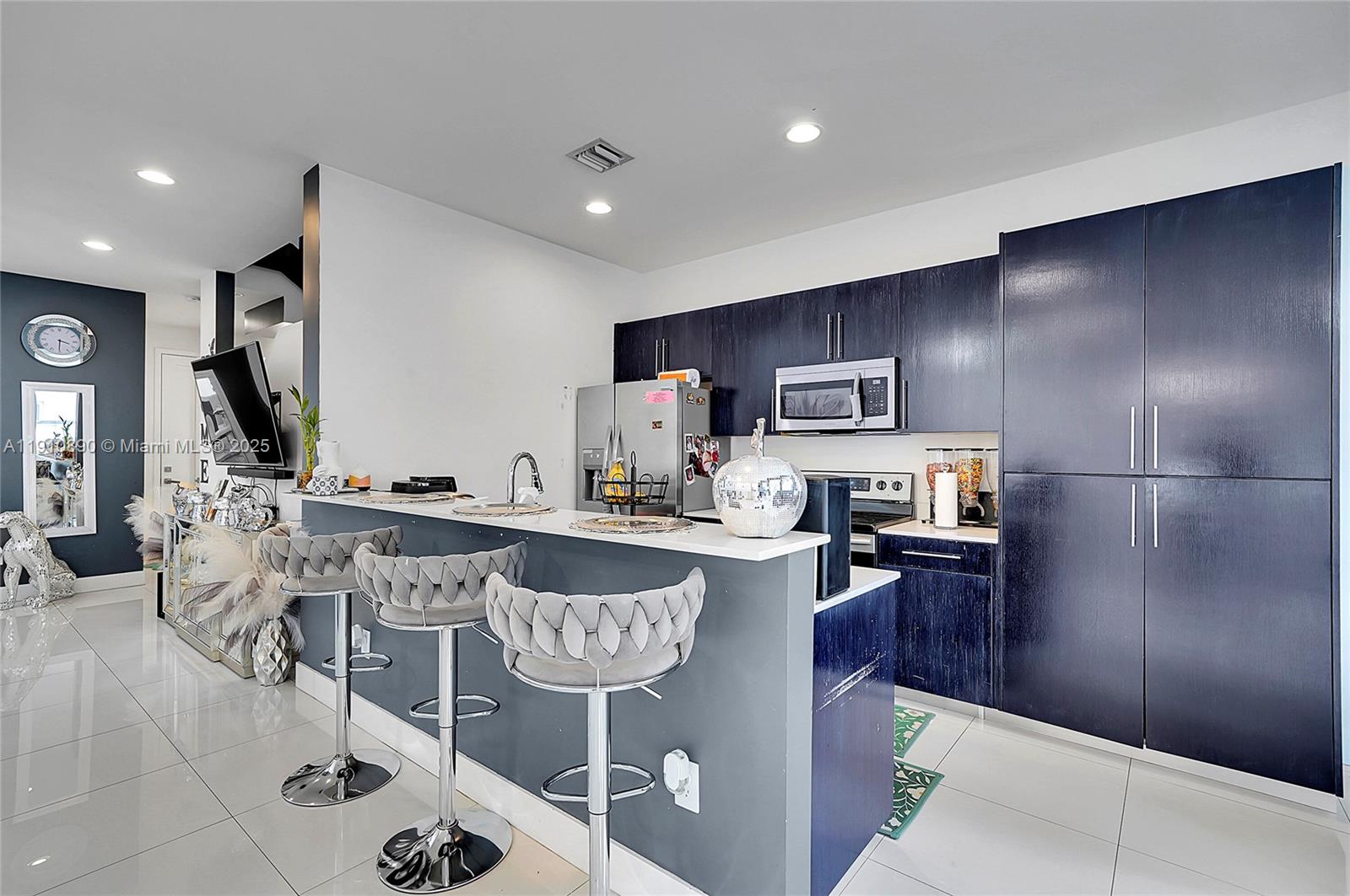 140 South E 7th Way Pompano Beach, FL 33060 - Photo 12 of 40 a kitchen with stainless steel appliances granite countertop a sink and a refrigerator