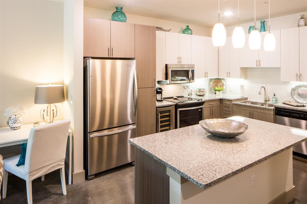7518 Eastern Avenue, Unit 101 Dallas, TX 75209 - Photo 1 of 1 a kitchen with granite countertop kitchen island stainless steel appliances a refrigerator sink stove microwave and cabinets