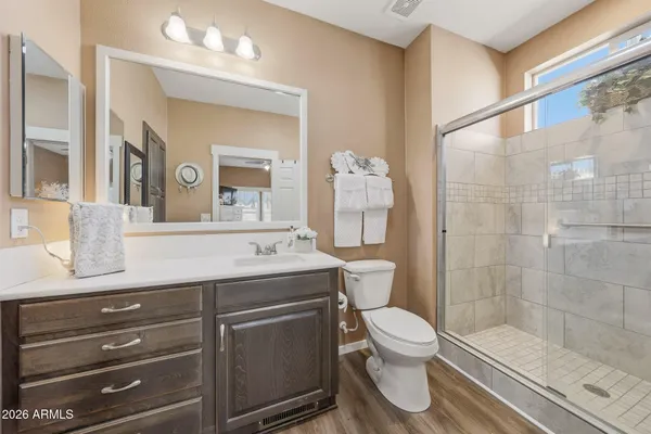 a bathroom with a granite countertop sink toilet a mirror and shower