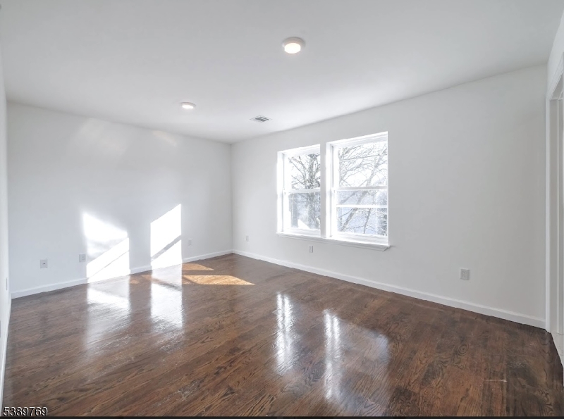 496 South 18th Street Newark, NJ 07103 - Photo 12 of 14 a view of an empty room with wooden floor and a window