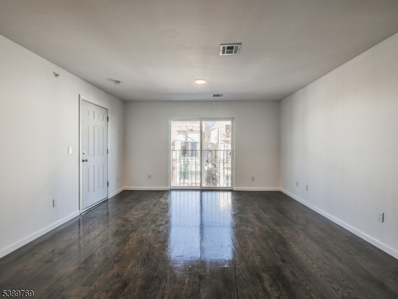 496 South 18th Street Newark, NJ 07103 - Photo 14 of 14 a view of an empty room with wooden floor and fan